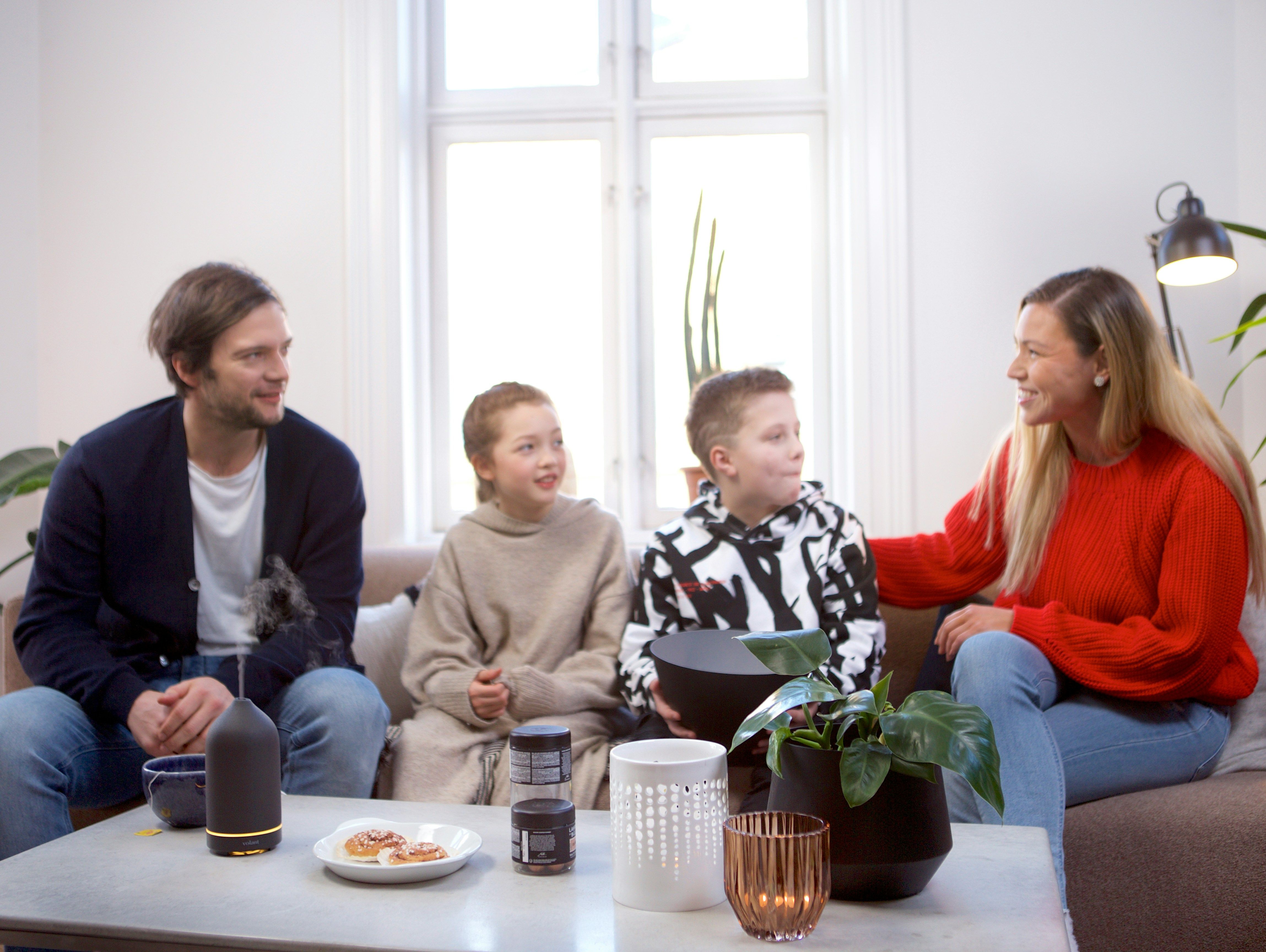 Familie sitzt mit Beraterin auf der Couch