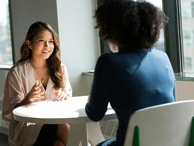 Zwei Frauen sitzen in einem Beratungsgespräch an einemTisch